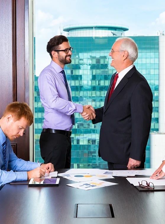 Attorney shaking hands with a client across a conference table