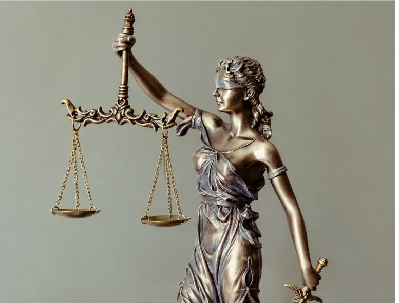 Bronze Lady Justice statue holding the scales of justice